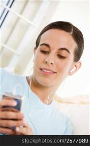 Close-up of a young woman listening to an MP3 player