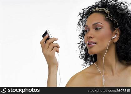 Close-up of a young woman listening to an MP3 player