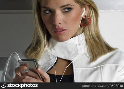 Close-up of a young woman listening to an MP3 player