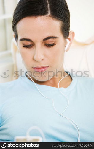 Close-up of a young woman listening to an MP3 player