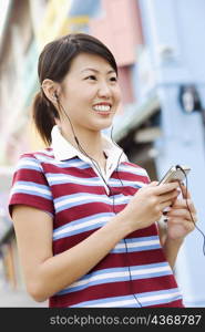 Close-up of a young woman listening to an MP3 player