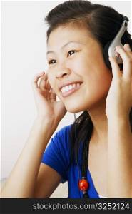 Close-up of a young woman listening to music and smiling