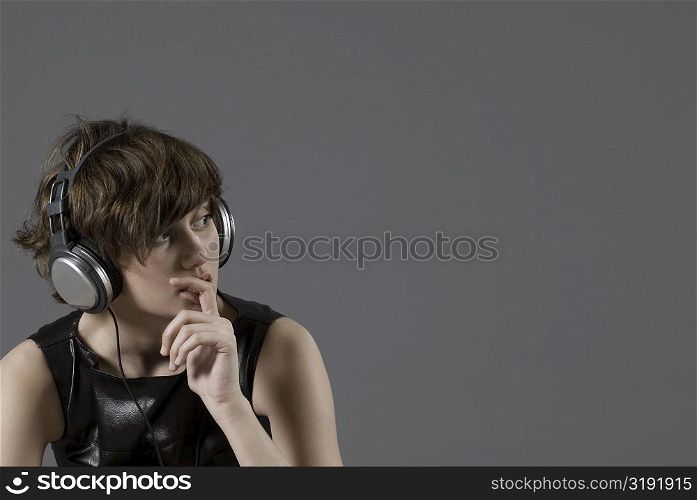 Close-up of a young woman listening to music and thinking