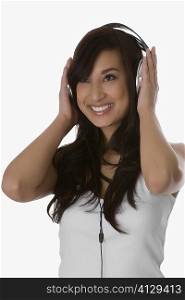 Close-up of a young woman listening to music with headphones and smiling