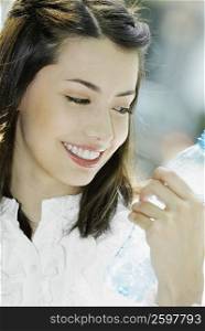 Close-up of a young woman looking a bottle of water