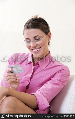 Close-up of a young woman looking at a credit card