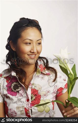 Close-up of a young woman looking at a flower