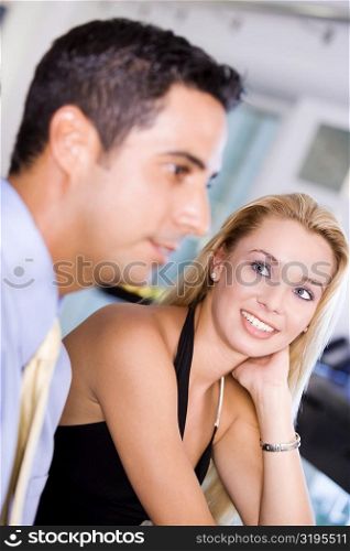 Close-up of a young woman looking at a mid adult man
