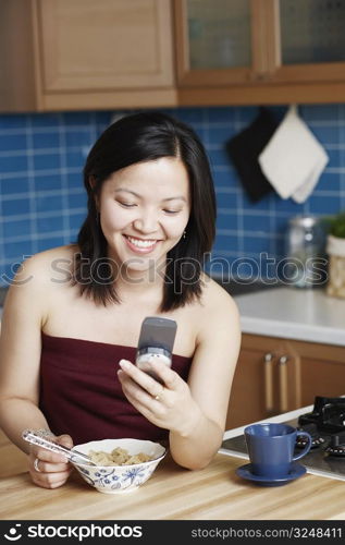 Close-up of a young woman looking at a mobile phone smiling