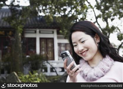 Close-up of a young woman looking at a mobile phone smiling