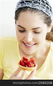 Close-up of a young woman looking at a strawberry tart