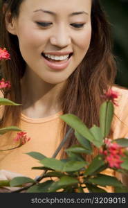 Close-up of a young woman looking at flowers and smiling