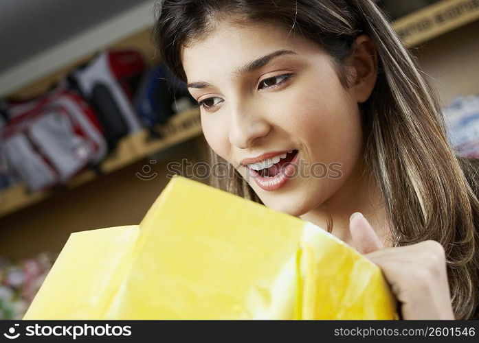 Close-up of a young woman looking in a shopping bag