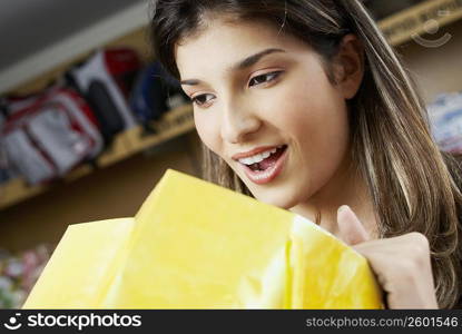 Close-up of a young woman looking in a shopping bag