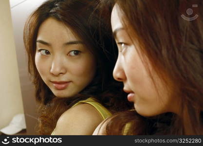 Close-up of a young woman looking in the mirror