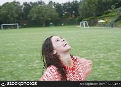 Close-up of a young woman looking up in a playing field