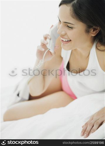 Close-up of a young woman lying down and using a telephone