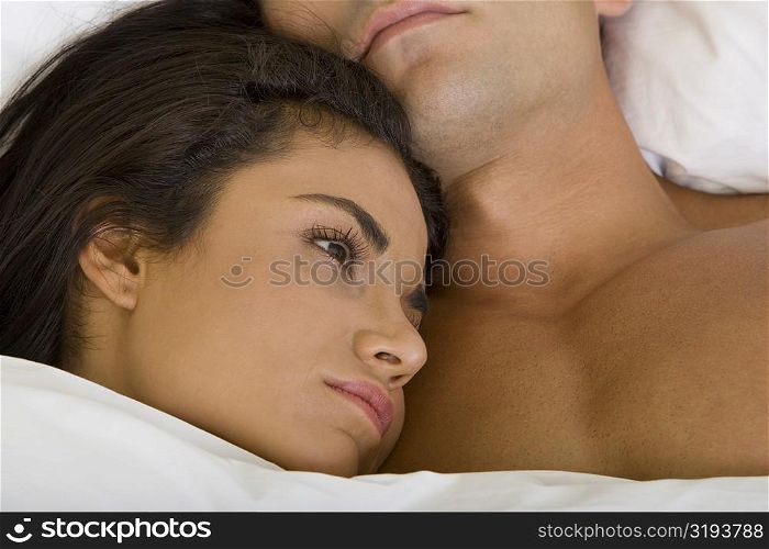 Close-up of a young woman lying down with her head on a young man&acute;s chest