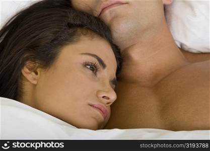Close-up of a young woman lying down with her head on a young man&acute;s chest