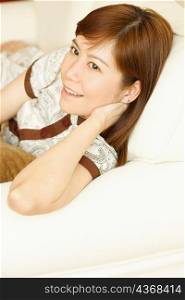 Close-up of a young woman lying on a couch and smiling
