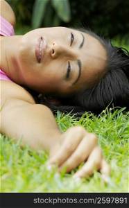 Close-up of a young woman lying on the grass