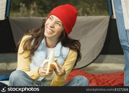 Close-up of a young woman peeling a banana