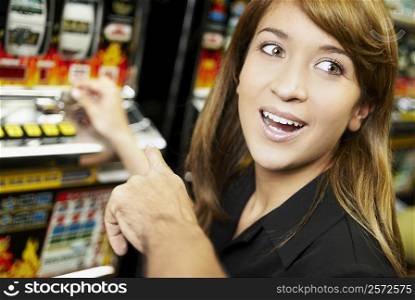 Close-up of a young woman playing on a slot machine at a casino