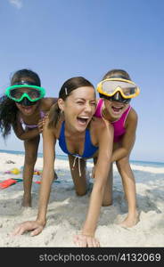 Close-up of a young woman playing with two girls on the beach