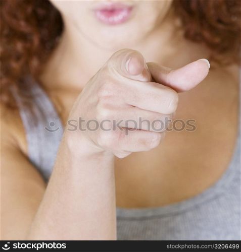 Close-up of a young woman pointing forward
