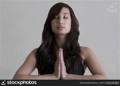 Close-up of a young woman practicing yoga in a prayer position