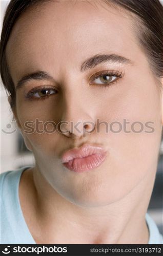 Close-up of a young woman puckering her lips