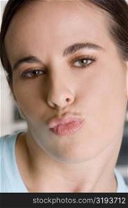 Close-up of a young woman puckering her lips