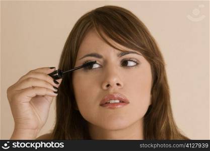Close-up of a young woman putting on mascara