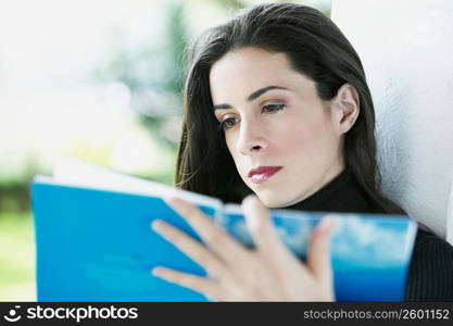 Close-up of a young woman reading a book