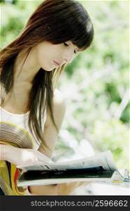 Close-up of a young woman reading a magazine
