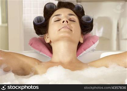 Close-up of a young woman relaxing in a bubble bath