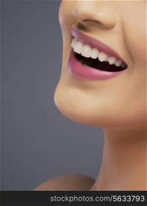 Close-up of a young woman&rsquo;s beautiful smile over colored background