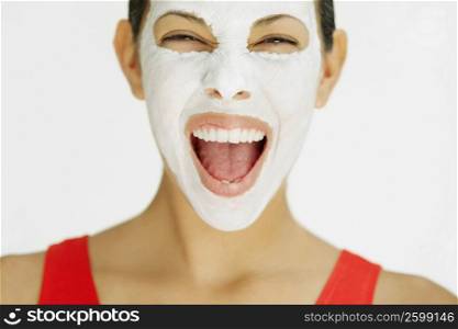 Close-up of a young woman shouting with facial mask on her face