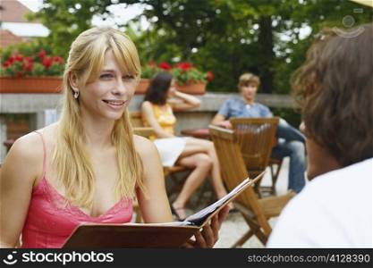 Close-up of a young woman sitting in front of a man