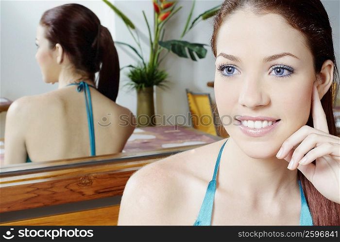 Close-up of a young woman sitting in front of a mirror