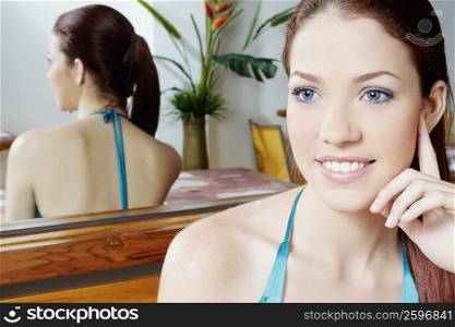 Close-up of a young woman sitting in front of a mirror