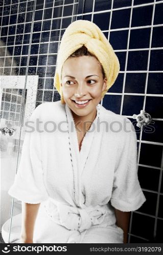 Close-up of a young woman sitting in the bathroom and smiling