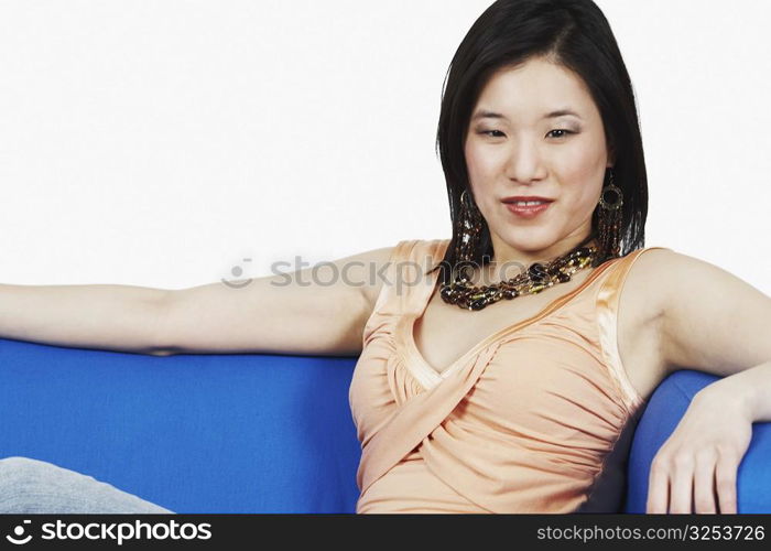 Close-up of a young woman sitting on a couch