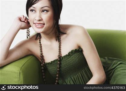 Close-up of a young woman sitting on a couch smiling