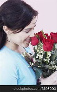Close-up of a young woman smelling a bunch of roses