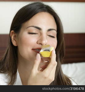 Close-up of a young woman smelling a cupcake