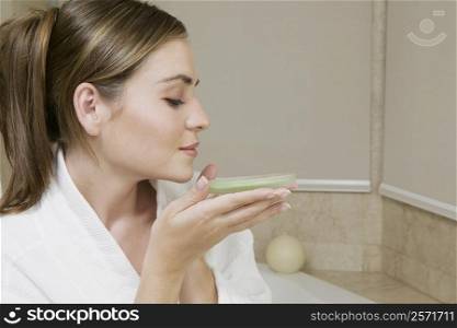 Close-up of a young woman smelling a dish of bath crystals