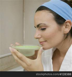 Close-up of a young woman smelling a dish of bath crystals