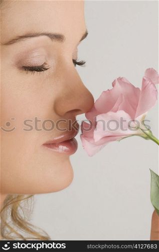 Close-up of a young woman smelling a flower