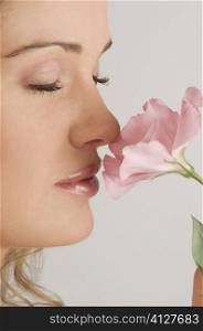 Close-up of a young woman smelling a flower